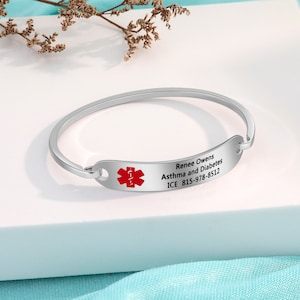 May include: Silver medical alert bracelet with a red medical symbol and the text "Renee Owens Asthma and Diabetes ICE 815-978-8512".
