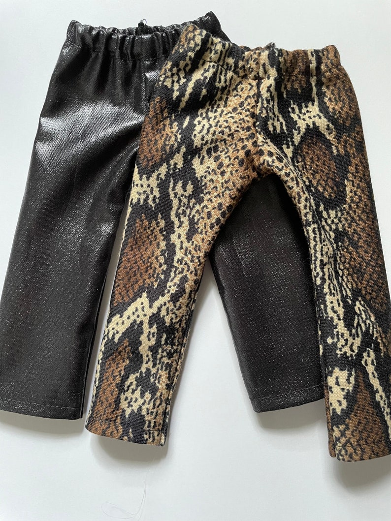 May include: Two pairs of leggings, one black with a shiny finish and one brown and black with a snake print.