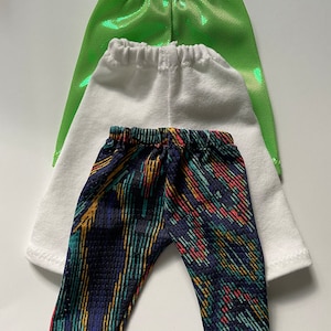 May include: Three pairs of leggings in different colors and patterns. The top pair is green, the middle pair is white, and the bottom pair is black with colorful stripes.