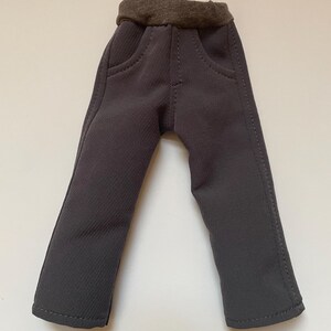 May include: Gray pants with a brown elastic waistband and two front pockets.