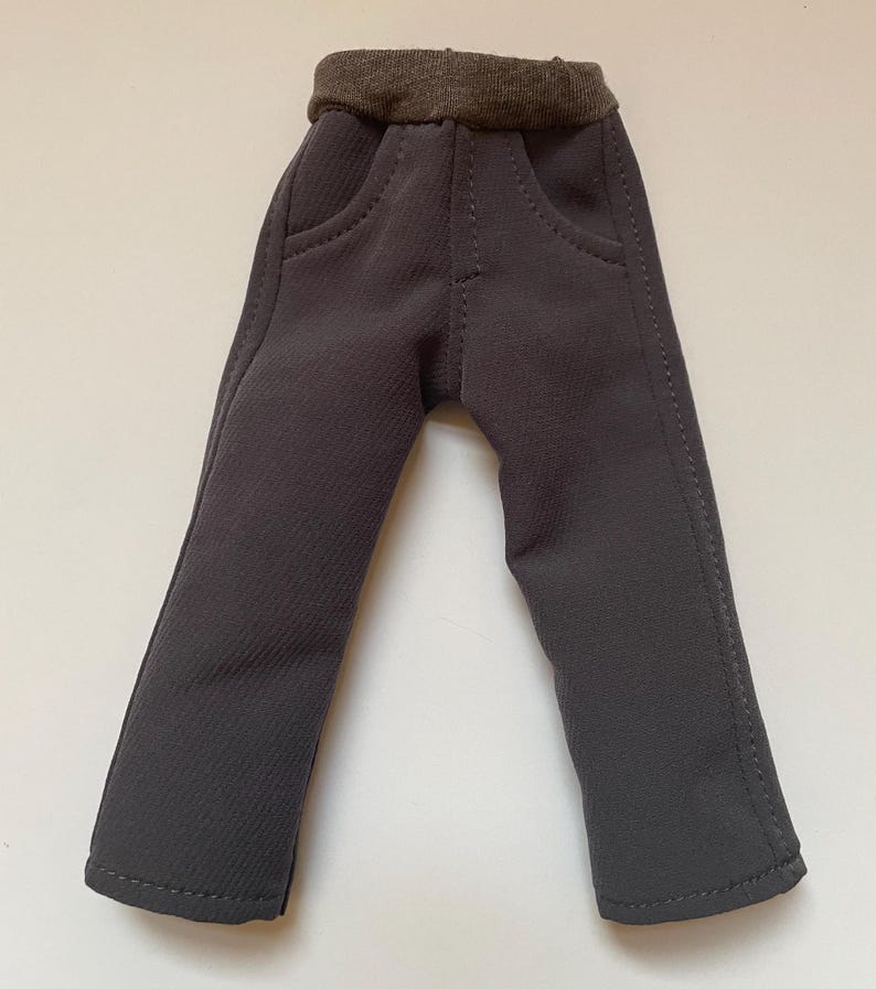 May include: Gray pants with a brown elastic waistband and two front pockets.