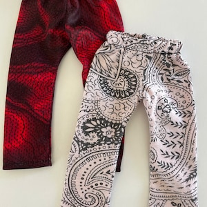 May include: Two pairs of leggings, one with a red and black swirl pattern and the other with a black and white paisley pattern.