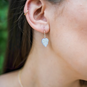 May include: A pair of silver earrings with a light blue leaf design.
