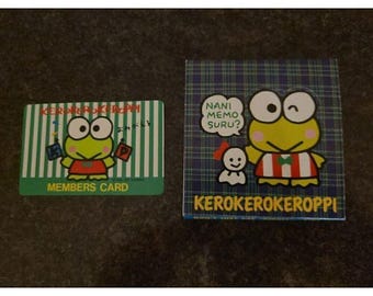 May include: A rectangular green and white striped members card featuring a cartoon frog character and the text KEROKEROKEROPPI MEMBERS CARD, alongside a square blue plaid notepad with the same frog and the text NANI MEMO SURU? KEROKEROKEROPPI.