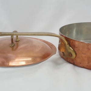 May include: Copper saucepan with a lid and brass handle. The saucepan has a hammered finish and the lid has a brass knob.