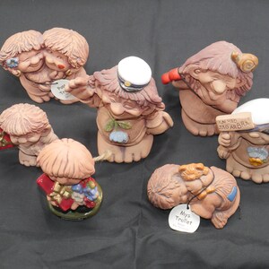 Pu&ograve; includere: Una collezione di sette piccole figurine in ceramica dipinte a mano. Le figurine sono tutte diverse, ma hanno tutte uno stile fantasioso e caricaturale. Alcune delle figurine tengono oggetti, come un cuore, una lumaca e un cartello che dice "En Vad Jag Arbra".