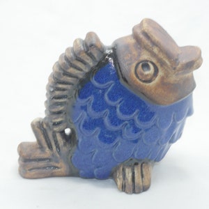May include: A blue and brown ceramic fish figurine with detailed scales and a textured finish.