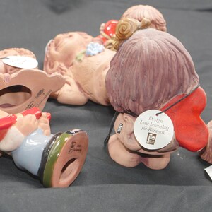 Pu&ograve; includere: Una collezione di cinque figurine in ceramica, ognuna con un design unico. Le figurine sono dipinte in vari colori, tra cui rosso, blu e marrone. Le figurine sono tutte in posizione seduta e guardano in direzioni diverse. Le figurine sono realizzate dalla societ&agrave; "JIE-Keramik" e sono progettate da Eva Jarenskog.