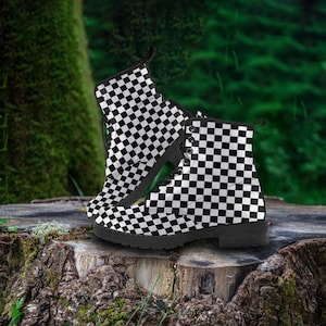 May include: A pair of black and white chequered combat boots. The boots feature a lace-up design and a thick, black sole. The boots are made of a durable material and are suitable for various occasions.