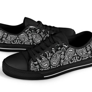 May include: Black canvas low-top trainers with a white paisley pattern.