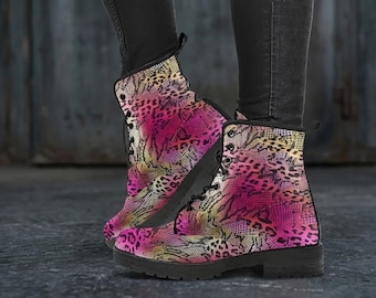 May include: Combat boots with a vibrant pink, yellow, and tan animal print pattern. The boots have black laces and soles. The boots are worn with black jeans.