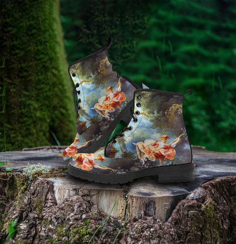 Front-facing product shot of vegan leather combat boots with intricate printed design on black lace-up boots