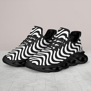 May include: Pair of black and white zebra print athletic shoes. The shoes have a wavy pattern design, black laces, and a thick black sole. The sneakers are designed for running and other athletic activities.