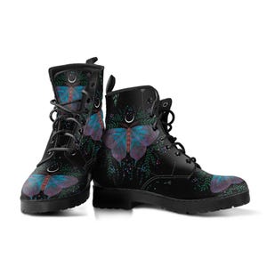 Pode incluir: Botas pretas com atacadores com um design de borboleta. As botas t&ecirc;m uma base preta com uma ilustra&ccedil;&atilde;o detalhada de uma borboleta em tons de azul e roxo. A borboleta &eacute; rodeada por folhagens verdes e pequenos detalhes florais.