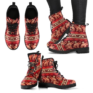 May include: Red leather boots with a patterned design featuring elephants and gold accents. The boots have black laces and a black sole.
