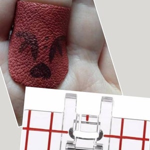 May include: A red leather thimble with a black angry face design. The thimble is shown on a finger.
