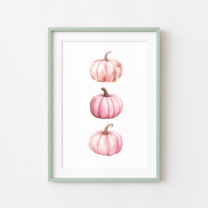 K&ouml;nnte beinhalten: Gerahmter Kunstdruck mit drei rosa Aquarellk&uuml;rbissen auf wei&szlig;em Hintergrund. Die K&uuml;rbisse haben braune Stiele. Der Rahmen ist hellgr&uuml;n.