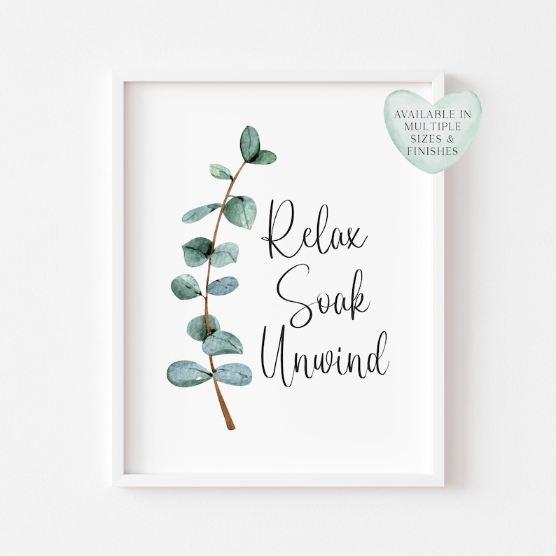 Puede incluir: Una impresi&oacute;n enmarcada con las palabras "Relax Soak Unwind" en escritura cursiva, acompa&ntilde;ada de una rama de eucalipto en acuarela. Una etiqueta en forma de coraz&oacute;n en la esquina superior derecha dice "Available in Multiple Sizes & Finishes".