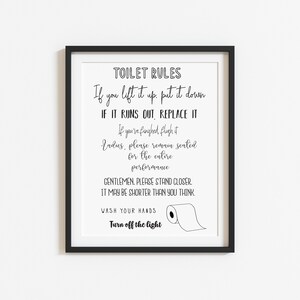 May include: A framed print with black text on a white background. The text reads "TOILET RULES" followed by humorous instructions and a drawing of a toilet paper roll. The frame is black.