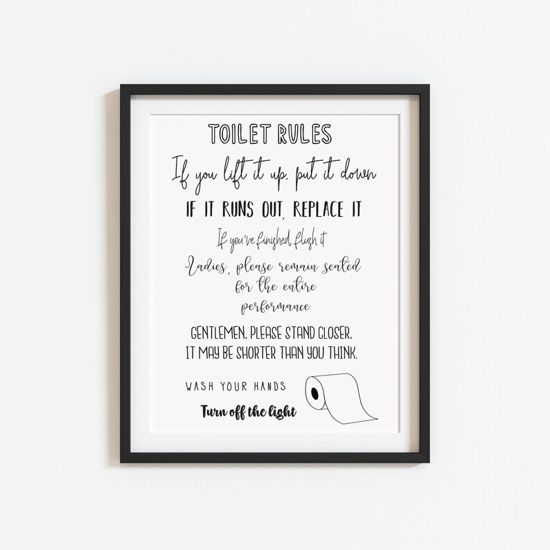 May include: A framed print with black text on a white background. The text reads "TOILET RULES" followed by humorous instructions and a drawing of a toilet paper roll. The frame is black.