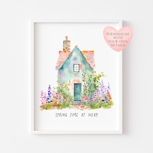 May include: A watercolour painting of a cottage with a green roof and door, framed in white. The cottage is surrounded by colourful flowers. Text reads "SPRING TIME AT NO.89". A pink heart graphic says "PERSONALISE WITH YOUR OWN DETAILS".