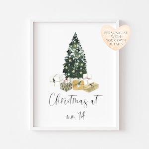 May include: A framed wall print featuring a watercolour illustration of a decorated Christmas tree surrounded by wrapped gifts. Below the tree, the text reads "Christmas at no. 14". A heart-shaped graphic includes the text "PERSONALIZE WITH YOUR OWN DETAILS".