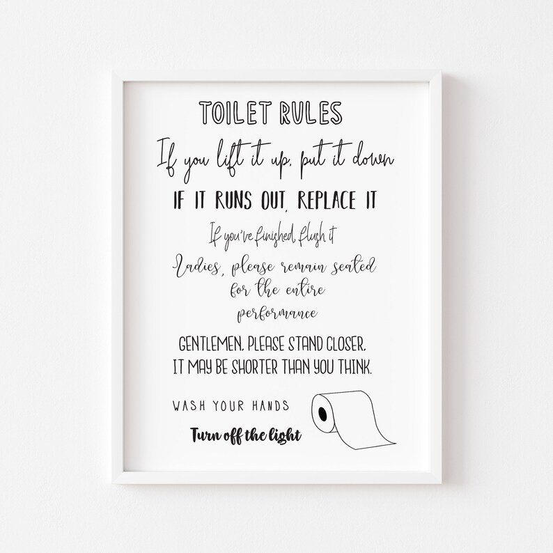 May include: A framed print with the words "TOILET RULES" in black script. The rules are listed below, including "If you lift it up, put it down" and "Turn off the light." A roll of toilet paper is illustrated.