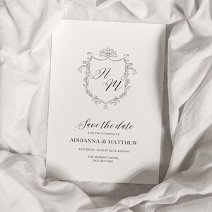 K&ouml;nnte beinhalten: Save-the-Date-Karte mit einem dekorativen Monogramm f&uuml;r Adrianna & Matthew. Die Hochzeit findet am Samstag, den 21. August um 16:00 Uhr im Marriott Hotel, Rue de Paris, statt.