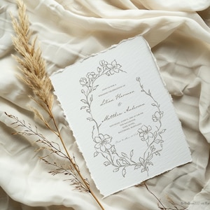 May include: A wedding invitation with a floral design in gray on a white background. The invitation reads "Join us for a wedding celebration of Lilian Harman & Matthew Anderson. Saturday, June 10, 2023 at 5:00 PM. The Ballroom, The Hotel, Baltimore, Maryland.  Reception to follow at 7:00 PM."