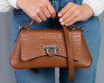 Bolso bandolera de piel texturizada marrón con estructura de cuero y estampado de cocodrilo.