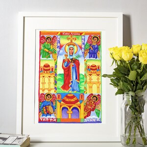 May include: A framed, colorful religious artwork featuring a central figure holding a chalice and palm branch, with the text "Kidist Arsema" at the top. The artwork includes angels, buildings, and vibrant colors, framed in a white border. Yellow roses in a glass jar are in the background.
