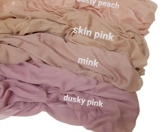 Op de afbeelding: Vier stofstalen in tinten roze en perzik. De stalen zijn gelabeld met "stoffig roze", "mink", "huid roze" en "stoffig perzik".