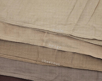 May include: A close-up of fabric swatches in shades of nude, beige, chestnut, earth, and chocolate. The colour names are printed in white on the fabric. The fabric appears to be linen or a similar natural fibre.