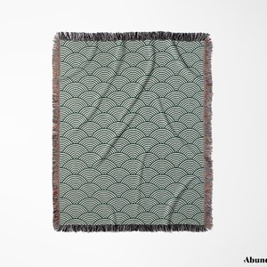 May include: A rectangular throw blanket featuring a repeating wave pattern in dark green and white. The blanket has a fringed edge in shades of brown and black. The design covers the entire surface of the blanket.