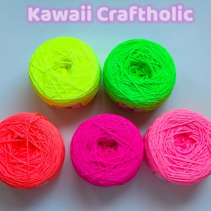 May include: Five balls of neon yarn in green, yellow, pink and orange. The yarn is wound into balls and ready for knitting or crocheting.