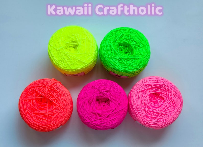 May include: Five balls of neon yarn in green, yellow, pink and orange. The yarn is wound into balls and ready for knitting or crocheting.