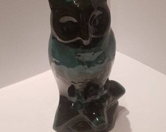 May include: A green and black ceramic owl figurine. The owl is perched on a branch and has a glossy finish.
