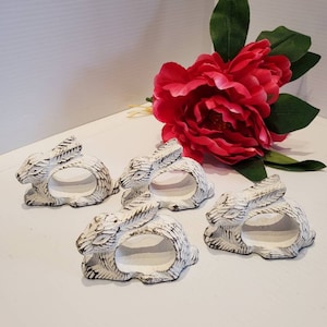 Może przedstawiać: Zestaw czterech białych obrączek na serwetki w kształcie królika. Obrączki wykonane są z żeliwa i mają postarzaną powierzchnię.