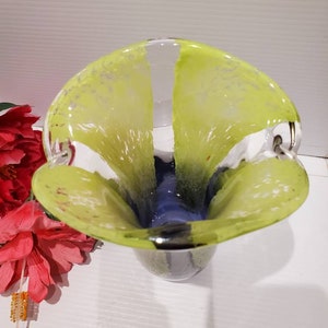 May include: A clear glass vase with a yellow and blue design. The vase has a wide mouth and a narrow base. It is a unique and stylish piece of home decor.