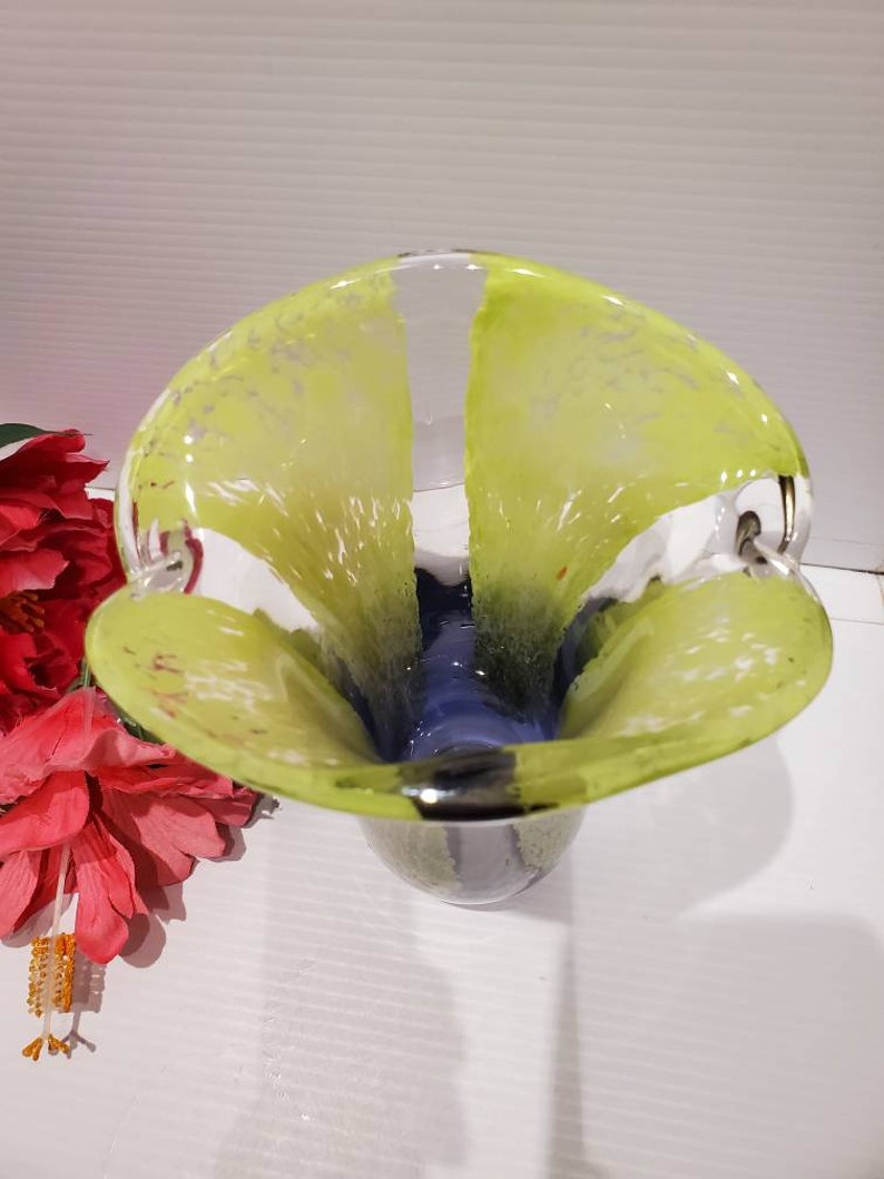 May include: A clear glass vase with a yellow and blue design. The vase has a wide mouth and a narrow base. It is a unique and stylish piece of home decor.