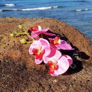 May include: Pink orchid flower hair clip with a clear acrylic charm that says "passion elite".