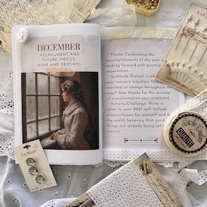 Pode incluir: Imagem de tema vintage com um livro aberto com "DEZEMBRO", uma ilustração de uma mulher perto de uma janela, alfinetes, lantejoulas douradas e um cartão com "La Mode" e três botões decorativos.