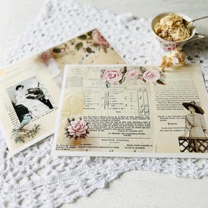 May include: A collection of vintage paper ephemera featuring floral and botanical designs. The items include aged paper with rose illustrations, a vintage photograph, and text fragments. A teacup with a dessert is in the background, on a white lace surface.