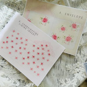 Könnte beinhalten: Zwei Blatt Briefpapier mit floralen Designs. Eines ist mit "A. ENVELOPE" beschriftet und zeigt rosa Rosen. Das andere, "B. COORDINATING LINING INSERT", hat kleinere rosa Blumenmuster. Der Hintergrund ist cremefarben.
