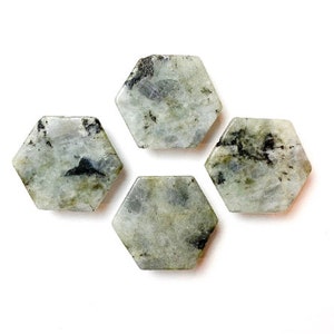 May include: Four hexagonal green and black gemstone coasters. The coasters are made of polished stone and have a natural, organic look.