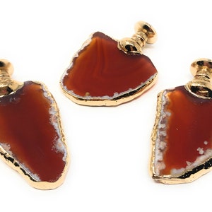 May include: Three agate drawer pulls with gold metal accents. The agate is a reddish-brown color with white veins.