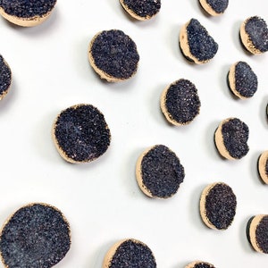 Peut inclure: Une collection de 15 sous-verres ronds en cristal noir et or. Chaque sous-verre a un bord doré et un centre en cristal noir scintillant.