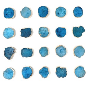 May include: Twenty-four blue agate coasters with gold trim. The coasters are arranged in a grid pattern on a white background.