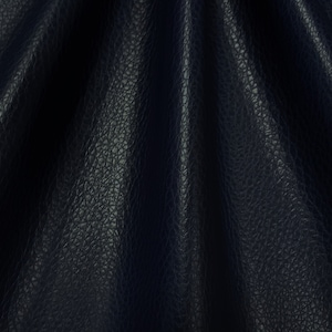 May include: Close-up of a dark blue textured leather fabric with a smooth, folded surface.