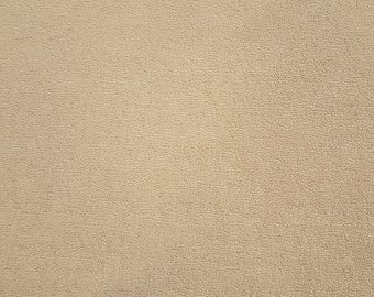May include: A close-up of a beige textured fabric surface.